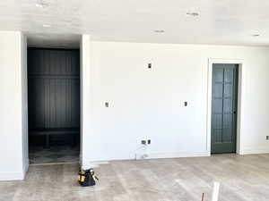 Interior space with light wood-style floors, a textured ceiling, and baseboards