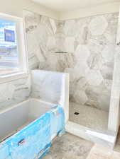 Bathroom with a tile shower and a bath