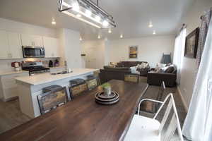 Dining area featuring baseboards, wood finished floors, and recessed lighting