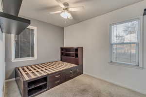 Bedroom featuring a ceiling fan, light colored carpet, and baseboards