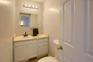 Half bathroom featuring visible vents, vanity, and toilet