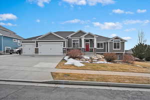 Craftsman inspired home with a garage, driveway, and a front lawn