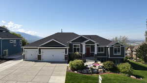 Craftsman house featuring driveway, a garage, a mountain view, a front lawn, and a shingled roof