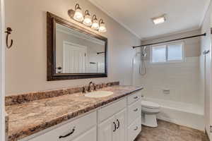 Full bathroom with toilet, washtub / shower combination, vanity, and crown molding