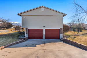 Garage with concrete driveway and a mountain view