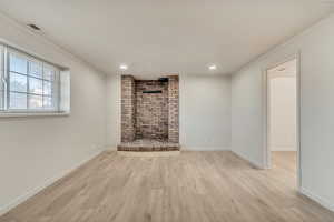 Unfurnished living room featuring baseboards, wood-style finished floors, and crown molding