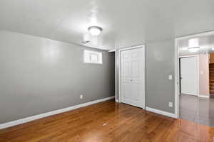 Unfurnished bedroom featuring wood finished floors and a closet