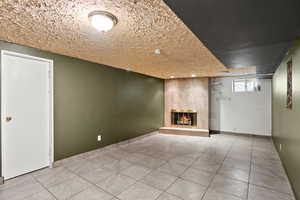 Below grade area with a tile fireplace, tile patterned floors, and recessed lighting