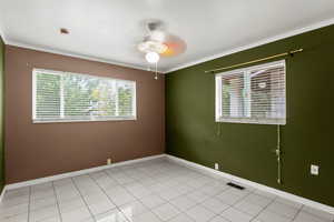 Unfurnished room featuring ceiling fan, crown molding, a smoke detector, and light tile patterned floors