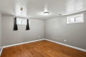Unfurnished room with wood finished floors and baseboards