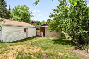 View of green lawn featuring an outbuilding