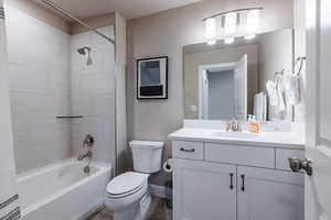 Bathroom featuring shower / washtub combination, baseboards, vanity, and toilet