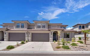 Mediterranean / spanish-style home featuring a garage, driveway, a tiled roof, and stucco siding