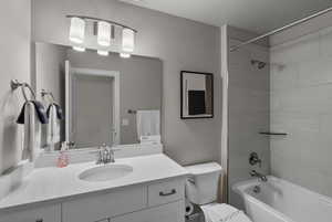 Bathroom with shower / washtub combination, vanity, and toilet