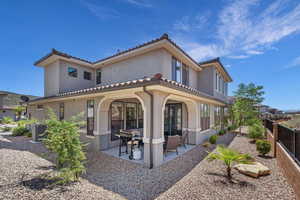 Rear view of property featuring central air condition unit, fence, a tile roof, stucco siding, and a patio area