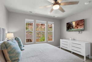 Bedroom featuring visible vents, ceiling fan, and a textured ceiling