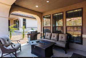 View of patio featuring grilling area and an outdoor living space with a fire pit