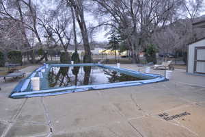 Community pool with a patio area, fence, and an outdoor structure