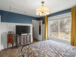 Bedroom with a wainscoted wall, wood finished floors.