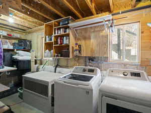 Laundry room featuring wood walls and independent washer and dryer