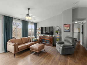 Living area with lofted ceiling, ceiling fan, and wood finished floors