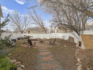 View of yard featuring a patio area, a fenced backyard, and a fire pit