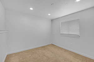 Spare room with baseboards, a textured ceiling, carpet flooring, and recessed lighting