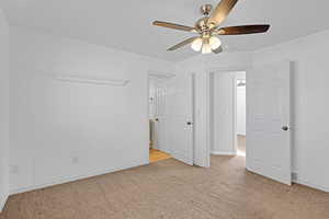 Unfurnished bedroom featuring carpet, a ceiling fan, and baseboards