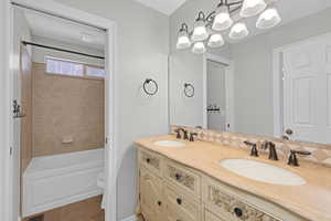 Bathroom featuring double vanity, tile patterned flooring, toilet, and a sink