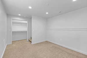 Unfurnished bedroom with recessed lighting, visible vents, baseboards, a closet, and carpet