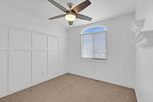 Unfurnished bedroom with ceiling fan, light colored carpet, visible vents, baseboards, and a closet