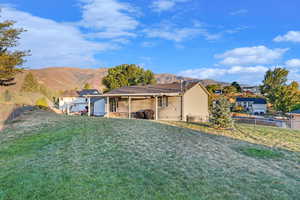 Rear view of property featuring a patio area, a fenced backyard, a mountain view, and a lawn