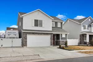 View of front of property with an attached garage, a shingled roof, fence, driveway, and a gate