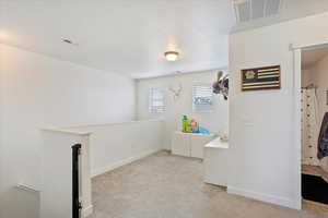 Loft area of the second floor featuring light carpet, visible vents, and baseboards