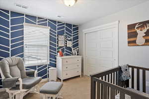 Bedroom featuring a closet, visible vents, and light colored carpet