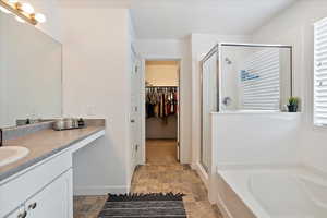 Bathroom with vanity, a stall shower, a garden tub.