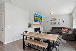 Dining space, an electric fireplace, baseboards, and wood finished floors