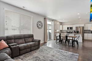 Living area featuring dark wood-style floors, recessed lighting, and baseboards