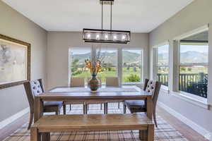 Dining room featuring a chandelier, light wood-type flooring, a mountain view, and baseboards