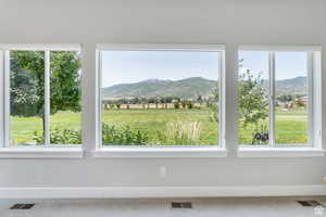 Interior space featuring a healthy amount of sunlight, visible vents, and a mountain view