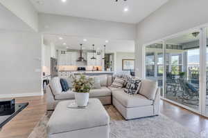 Living room with light wood-style floors, baseboards, and recessed lighting