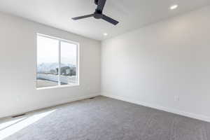 Carpeted spare room with baseboards, visible vents, and recessed lighting