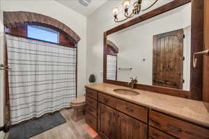 Full bath with wood finished floors, vanity, toilet, and a shower with curtain