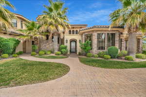 Mediterranean / spanish home featuring stone siding, a tile roof, a front lawn, and stucco siding