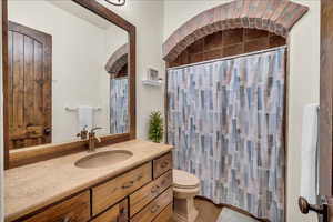 Bathroom with a shower with curtain, vanity, and toilet