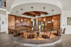Kitchen featuring brown cabinets, light wood finished floors, baseboards, and stainless steel appliances