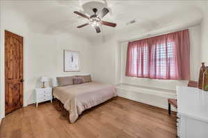 Bedroom with visible vents, ceiling fan, and light wood-style flooring
