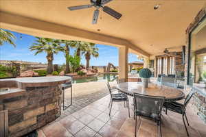 View of patio with ceiling fan, fence, a fenced in pool, and outdoor dining space