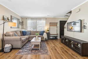 Living room featuring ornamental molding and wood finished floors