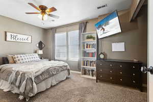 Bedroom featuring ceiling fan, carpet floors, visible vents, and baseboards